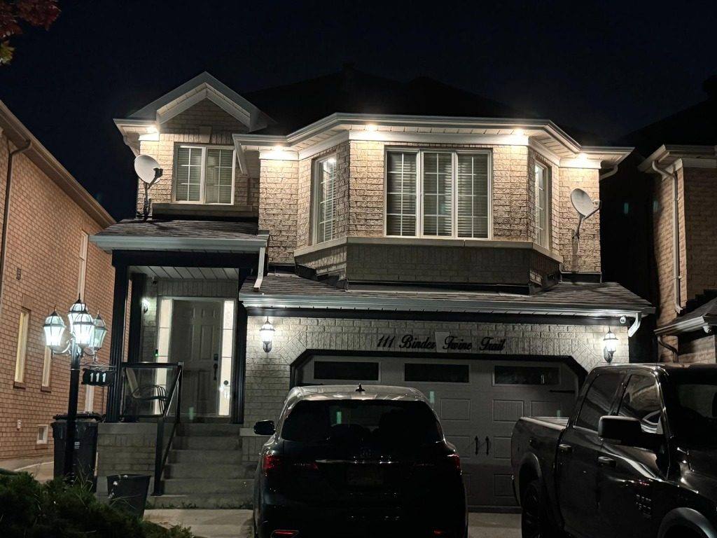 Two-story house with illuminated exterior soffit lighting at night